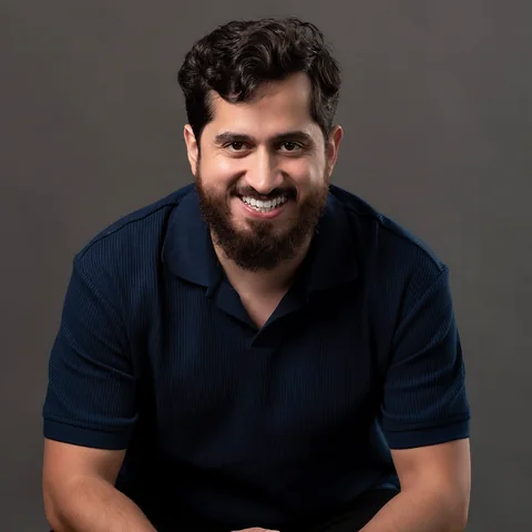 Professor Bruno sorrindo, de camisa polo azul-marinho